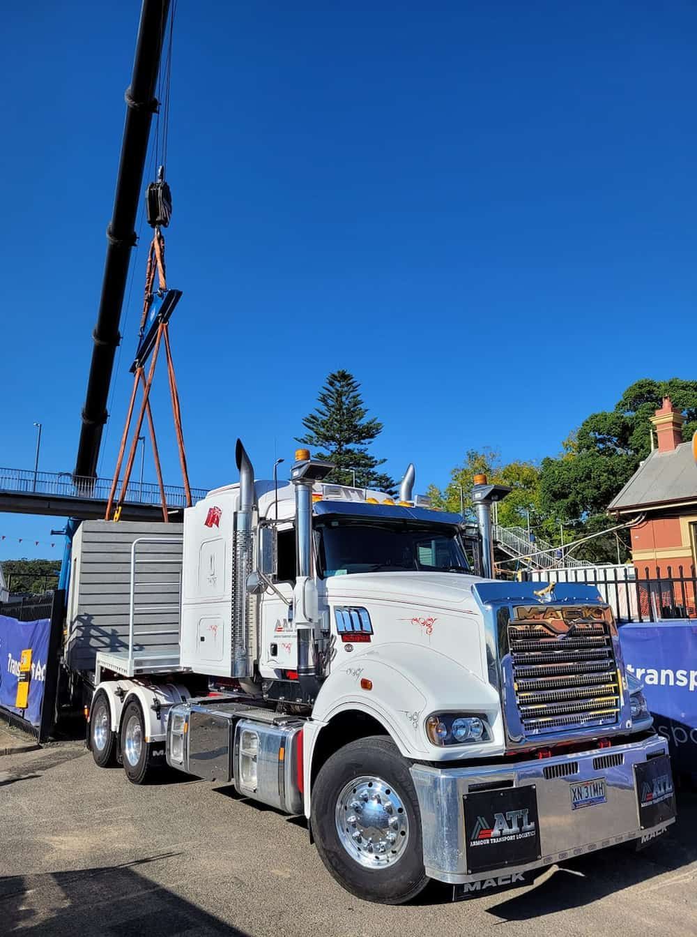 A White Semi Truck With A Crane Attached To It Is Parked In A Parking Lot — Armour Transport Logistics In Rutherford, NSW