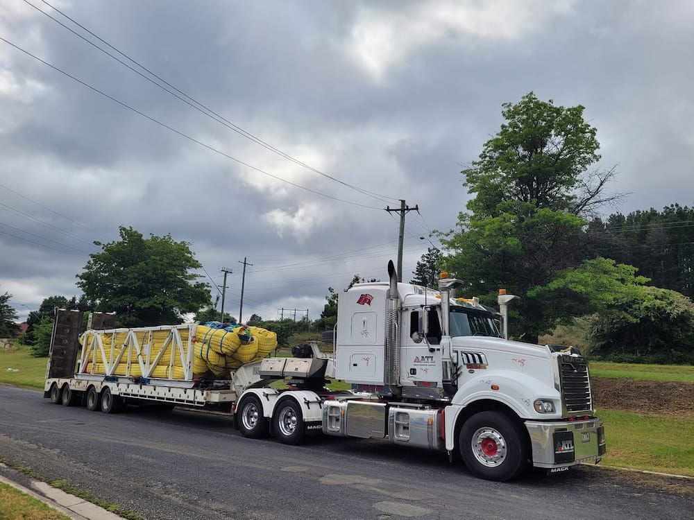 A White Semi Truck Is Driving Down A Road — Armour Transport Logistics In Narrabri, NSW