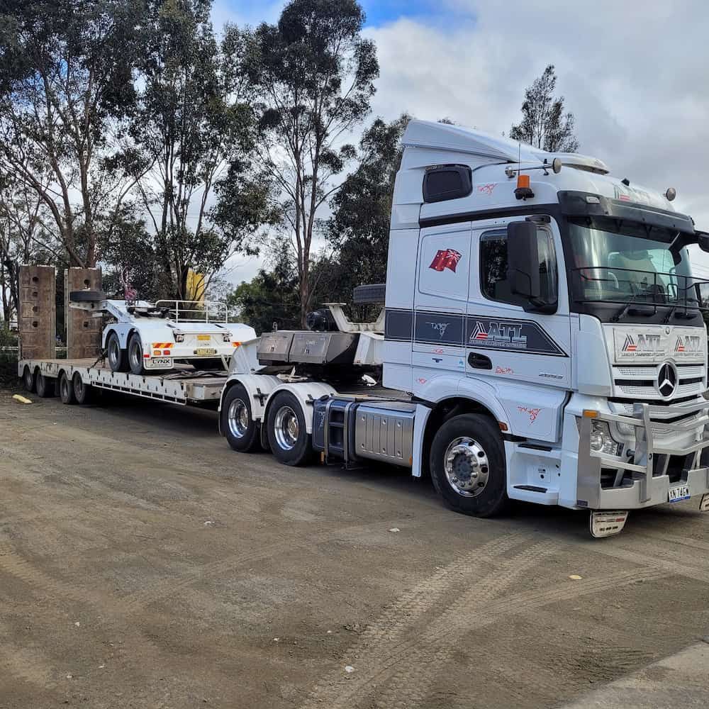 A Semi Truck Is Carrying A Car On A Trailer — Armour Transport Logistics In Muswellbrook, NSW