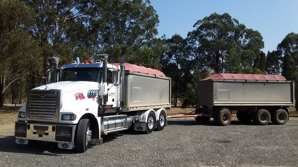 Two White Dog Trucks Parked Under Pergola — Armour Transport Logistics In Rutherford, NSW