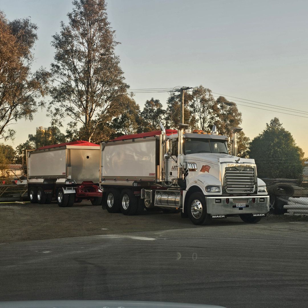 Two Dog Trucks Parked On Dirt— Armour Transport Logistics In Rutherford, NSW