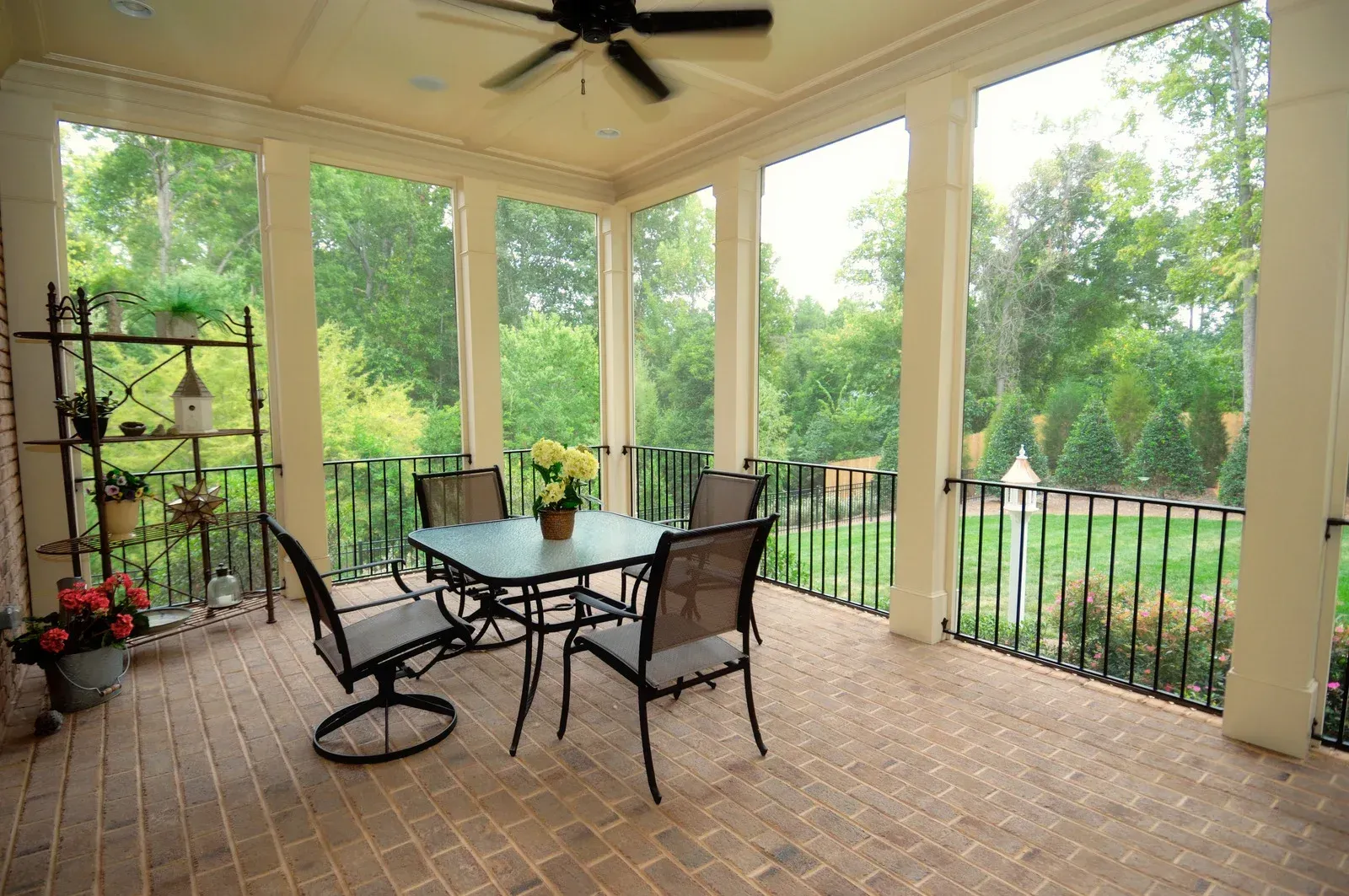 Stone outdoor pavilion with a dark wooden roof, built-in grill, and bench seating.