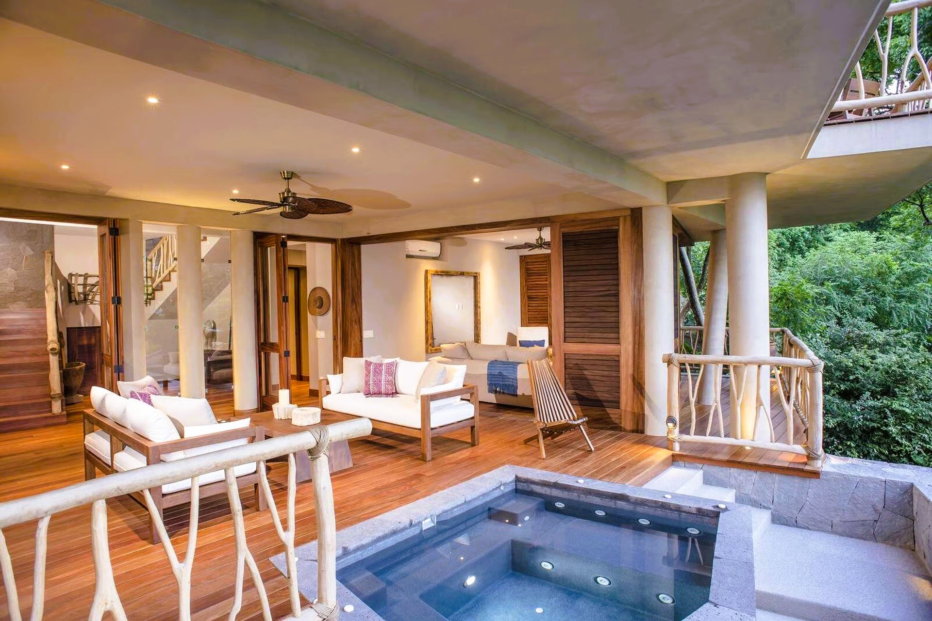 Outdoor living area with jacuzzi and wooden furniture; Costa Rican villa.