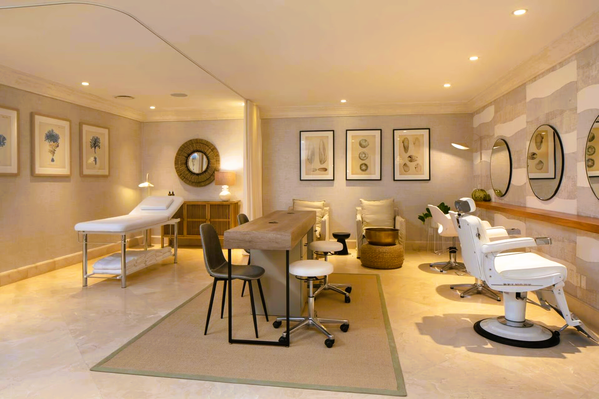 Salon interior with treatment bed, styling chairs, and a central workstation.