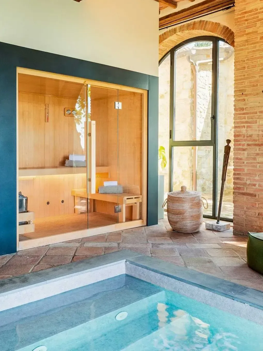 Spa area with sauna, jacuzzi, and large arched window.