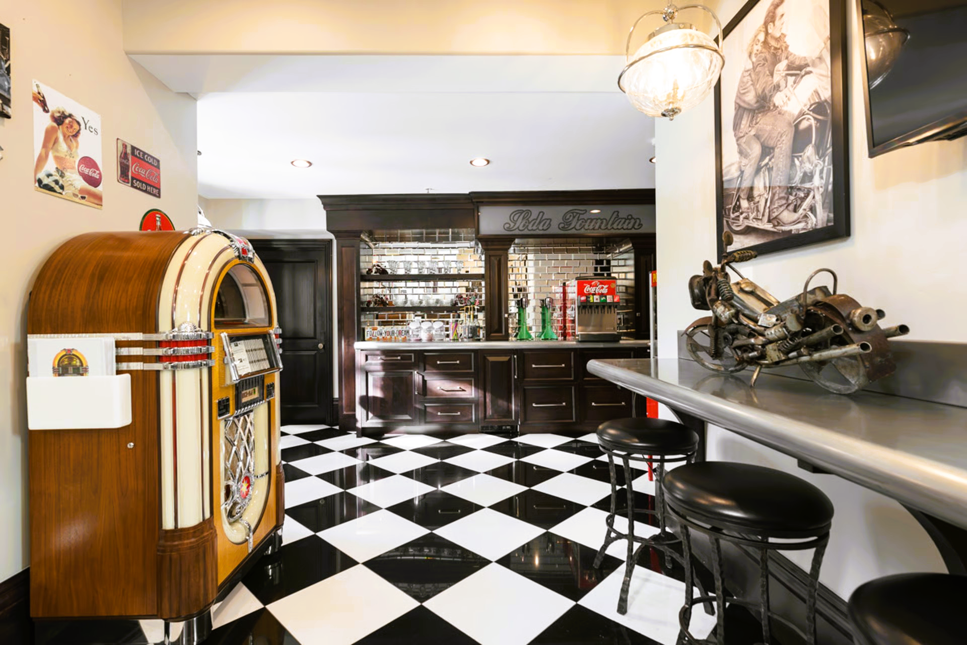Retro bar with a jukebox, checkerboard floor, and stools at a counter.