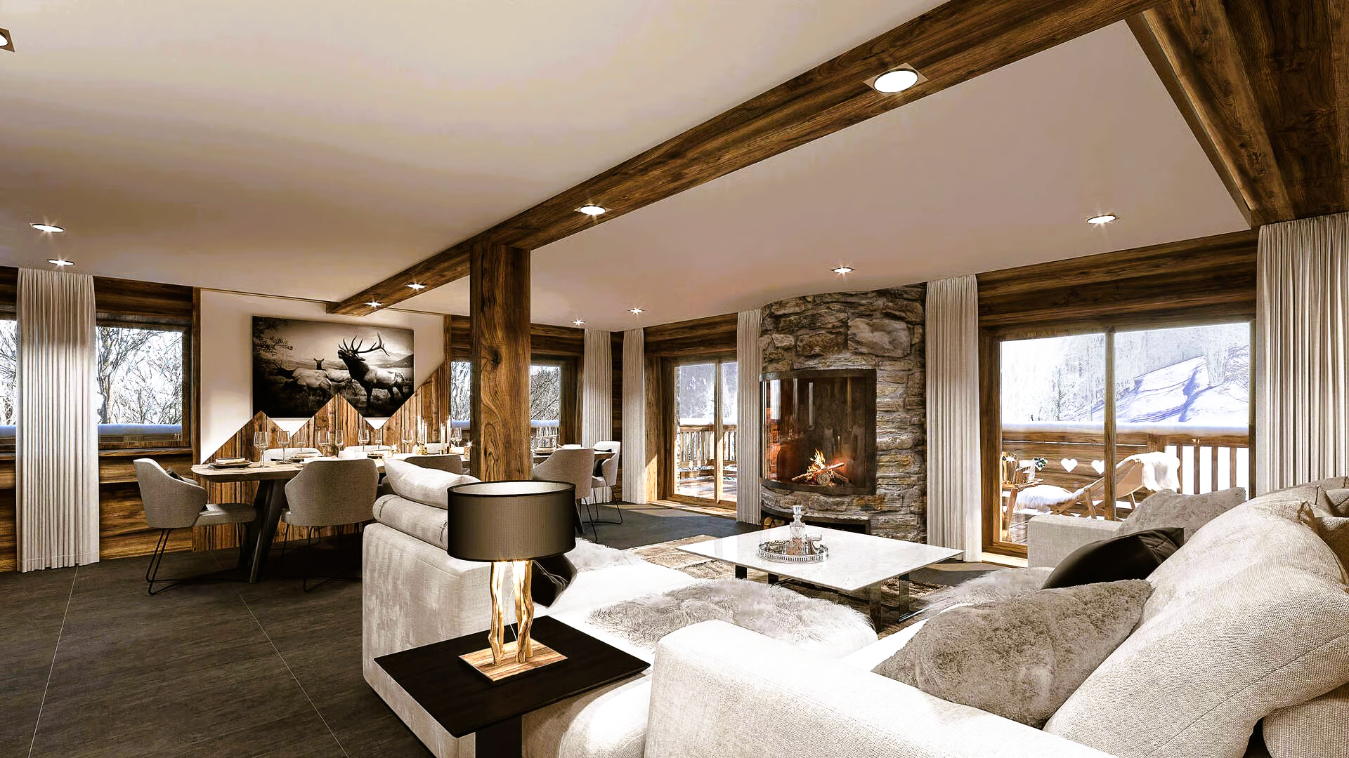 Cozy ski chalet living room with stone fireplace, snow outside windows, light-colored sofas, and wooden beams.