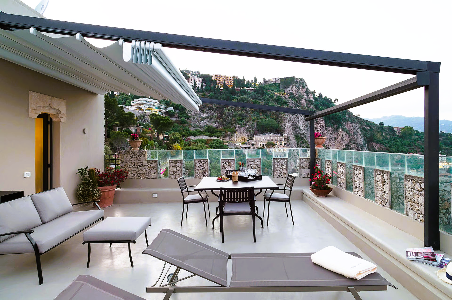Rooftop patio with mountain view, furnished with seating and dining area under a retractable awning.