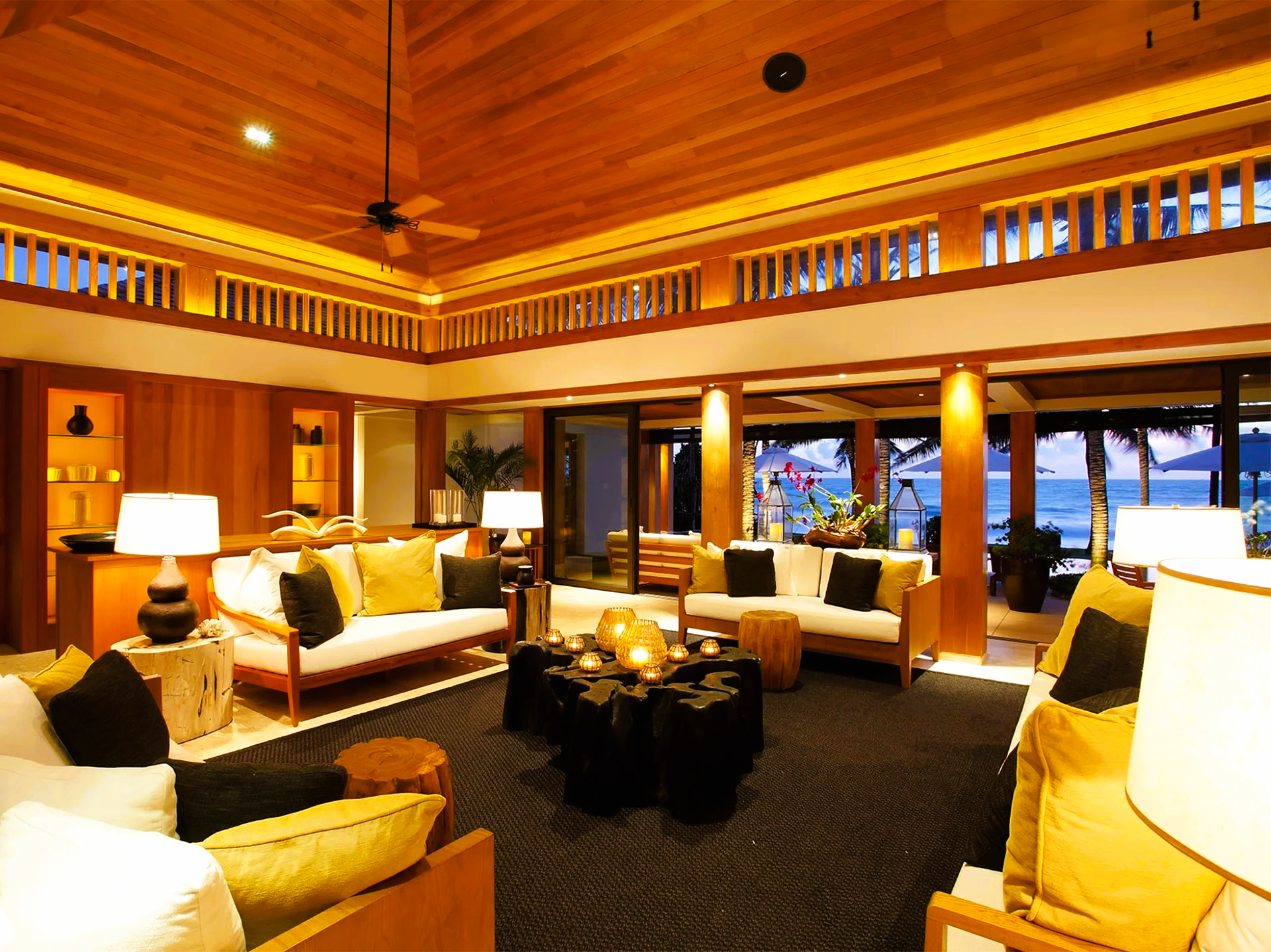 Luxurious beachfront living room with wood accents, white sofas, and ocean view.