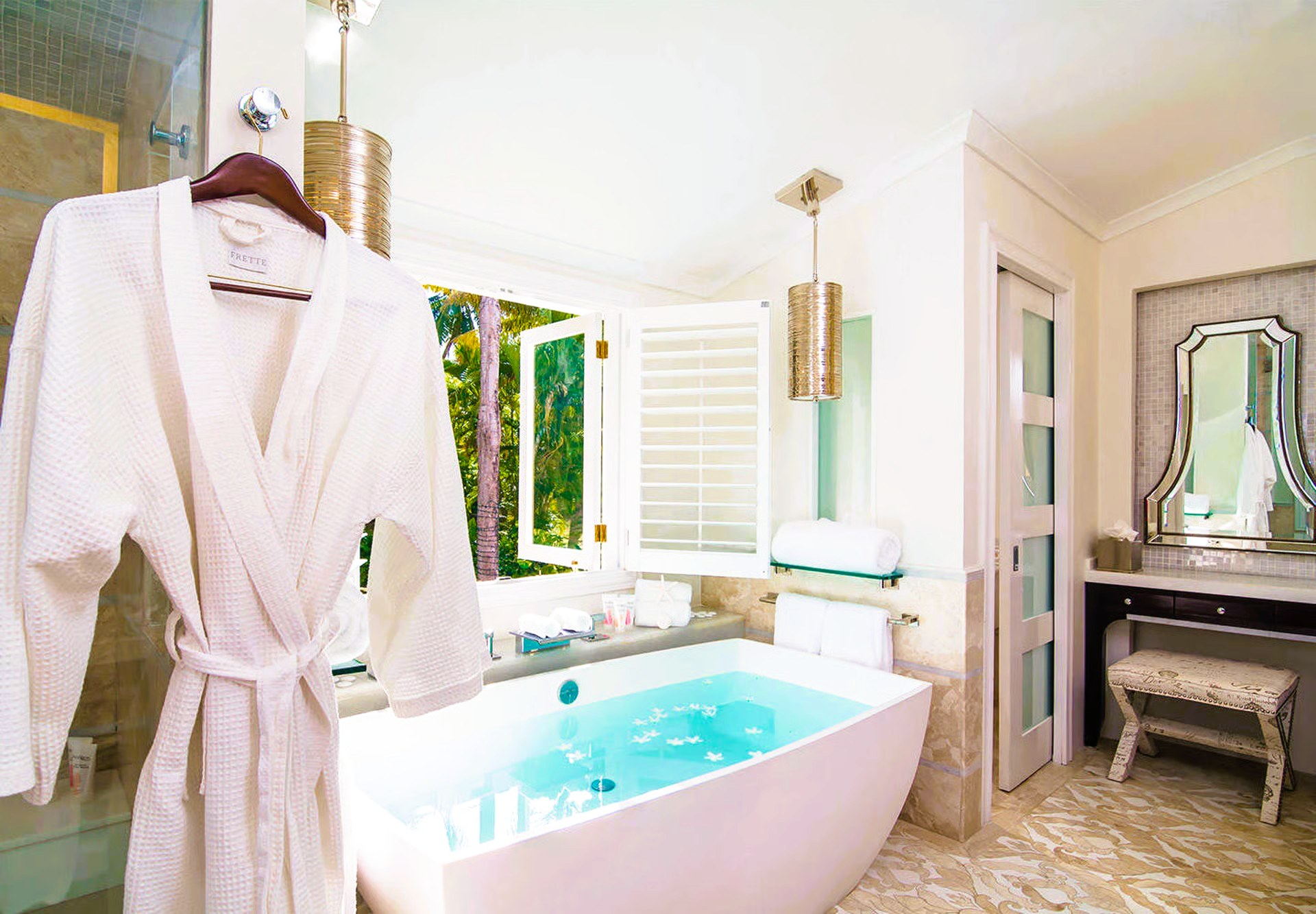 White bathrobe hanging in a luxurious bathroom with a soaking tub and vanity.