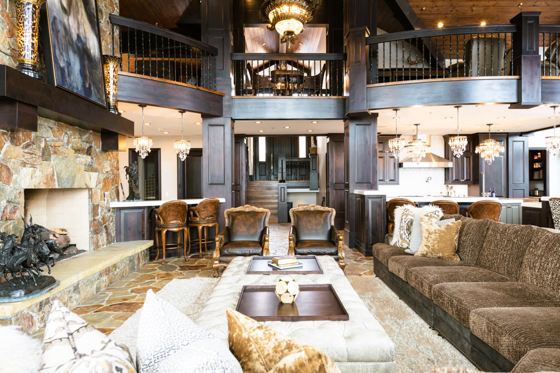 Spacious living area with stone fireplace, dark wood, and comfortable seating in a mountain home.