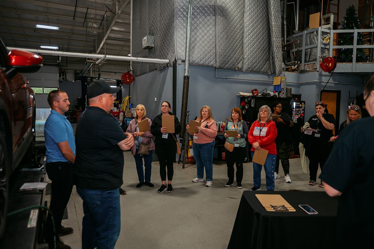 Group of women listening to explanation about vehicles, taking notes | Full Throttle Automotive LLC