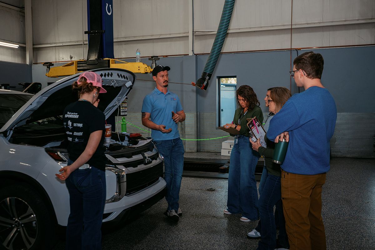 Technician explaining under the hood to a group of people | Full Throttle Automotive LLC