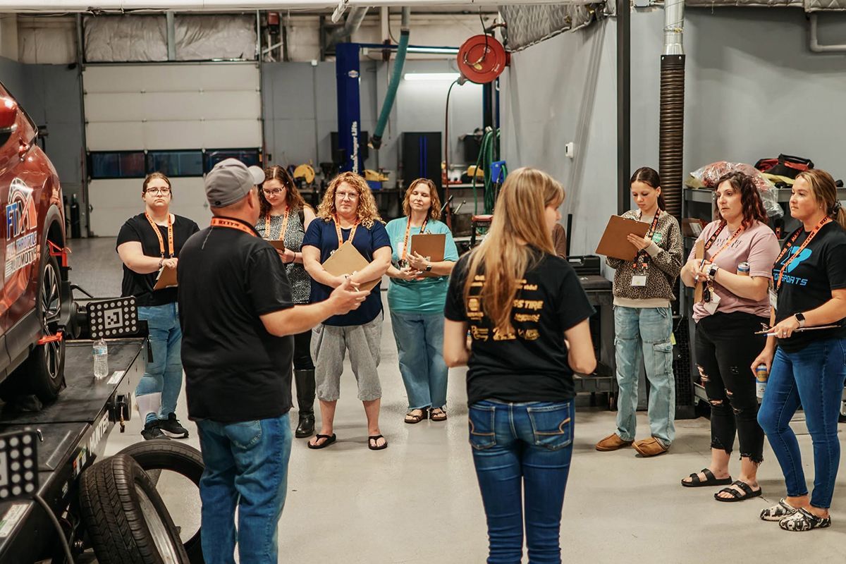 Technician explaining as women listen during Ladies Night | Full Throttle Automotive LLC