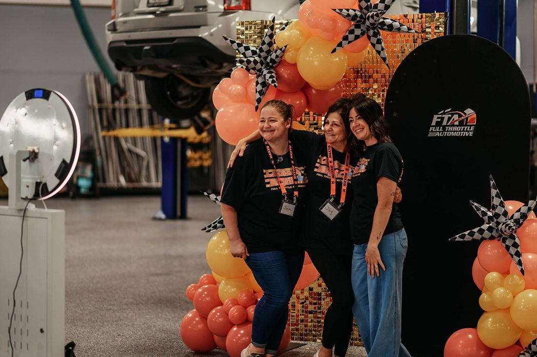 Three women posing together for a photo during Ladies Night | Full Throttle Automotive LLC