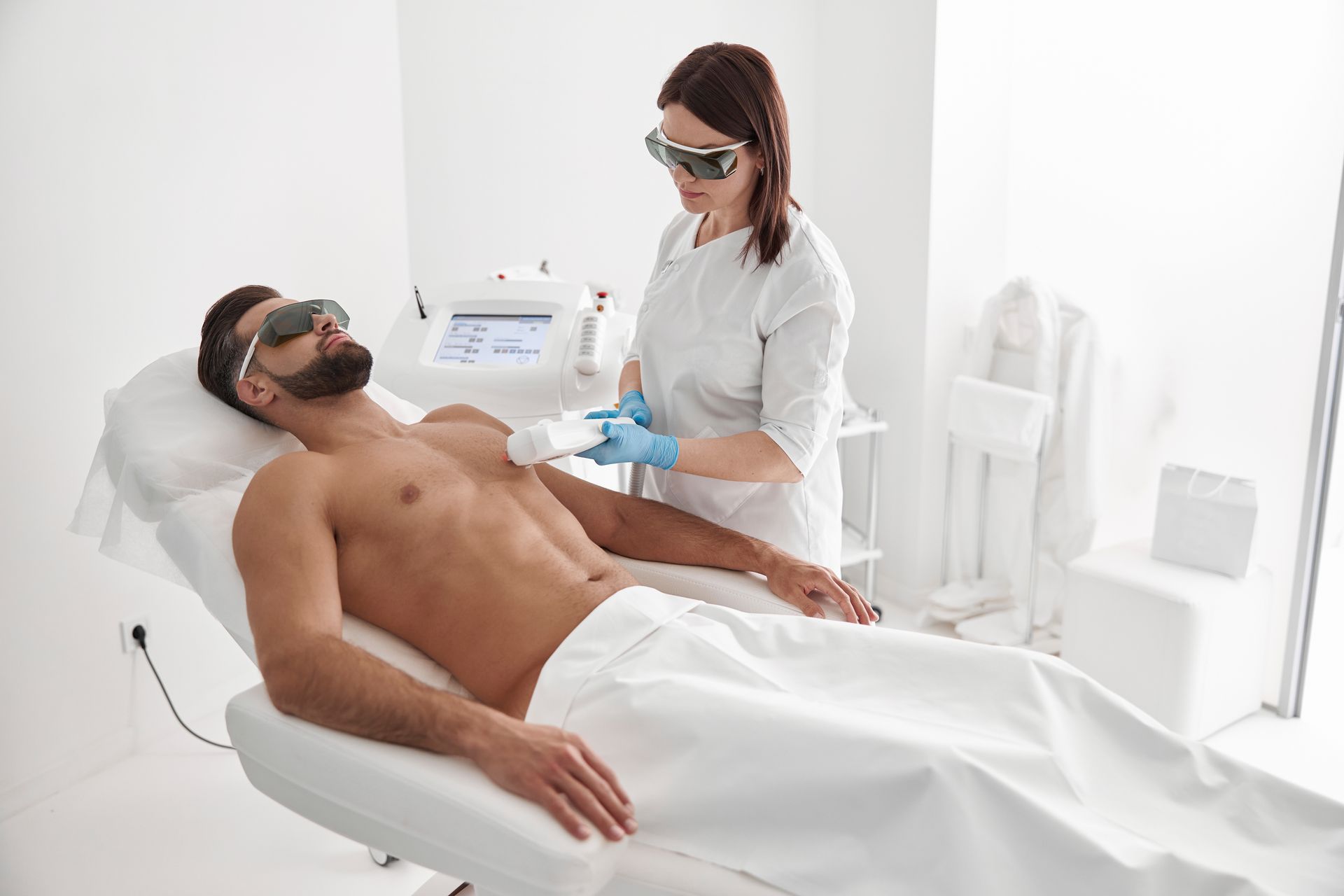 A man is getting a laser hair removal treatment on his chest.