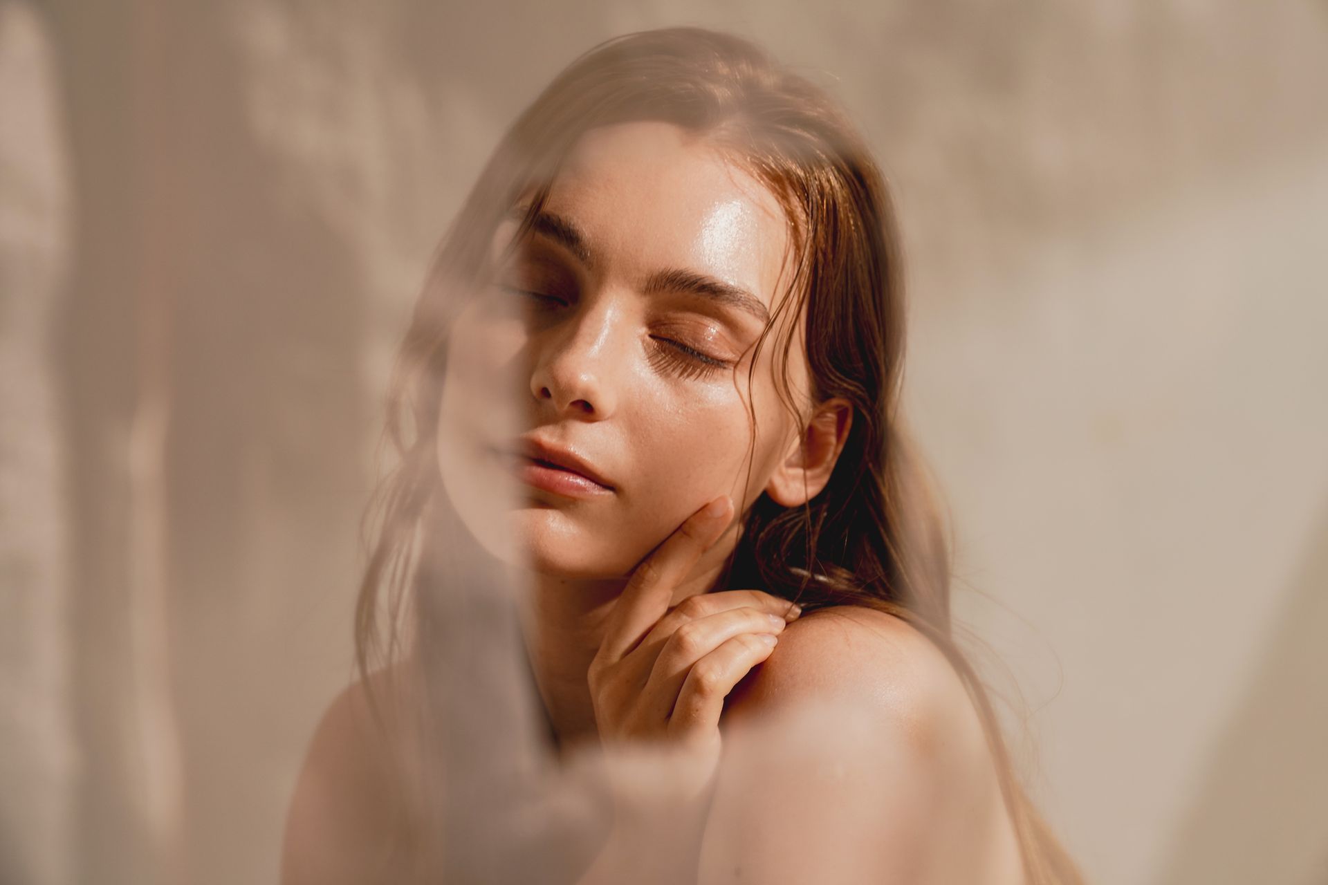 A close up of a woman 's face behind a clear curtain.