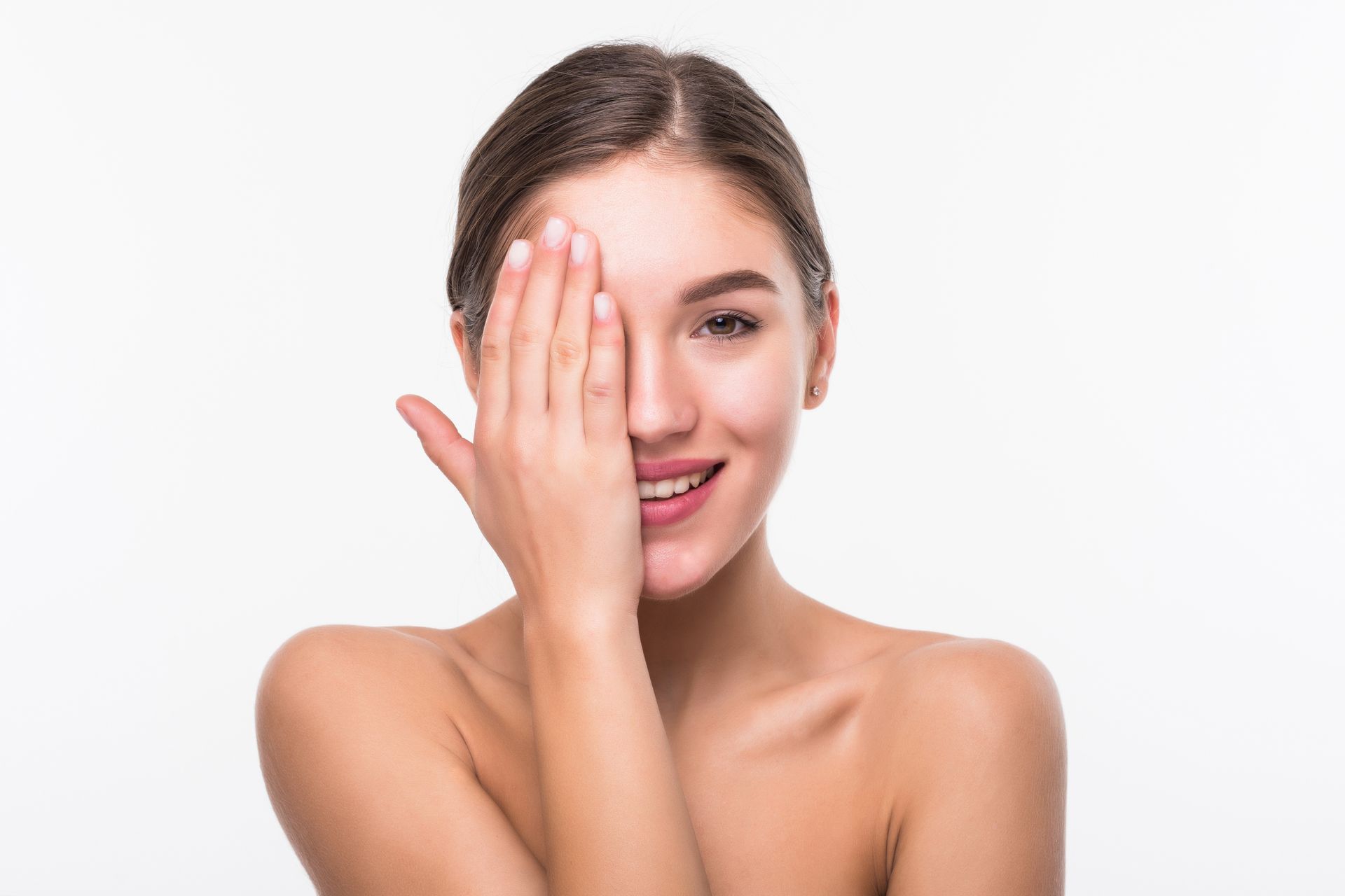 A woman is covering her eye with her hand.