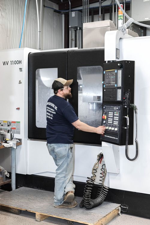 A man is working on a machine in a factory.