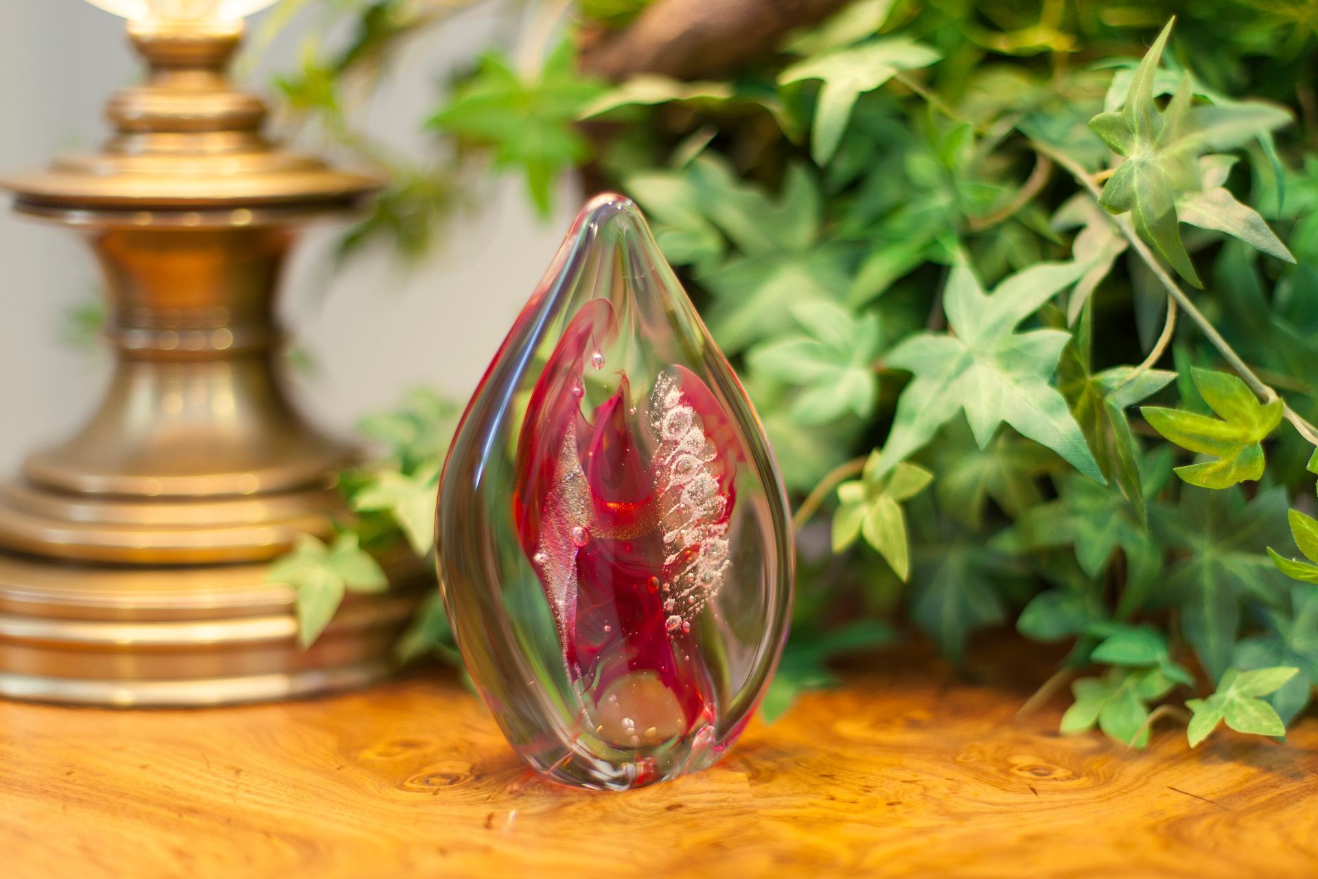 Red and clear blown glass statue with the fine powder of cremated remains swirled inside