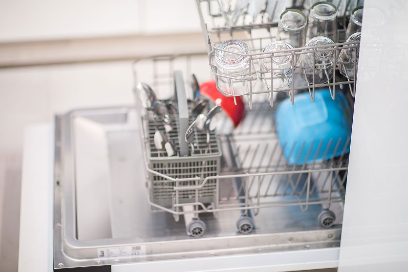 Open dishwasher with clean glass and dishes