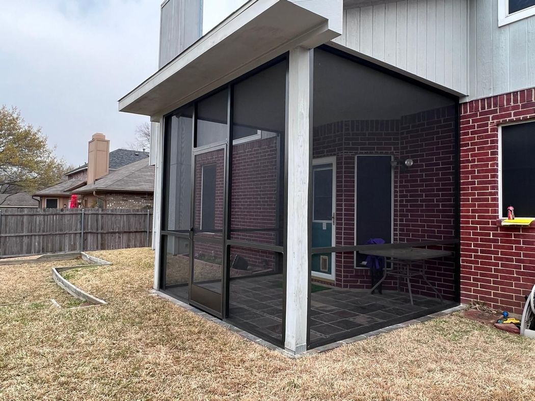 Screened patio next to brick house
