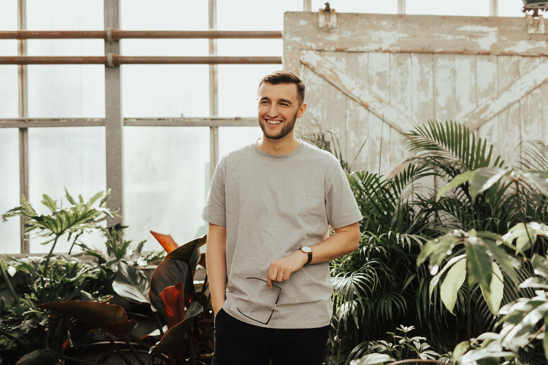 male smiling with plants around them