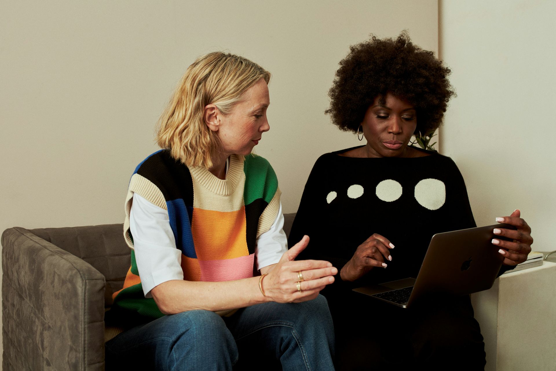 two people sitting on couch talking