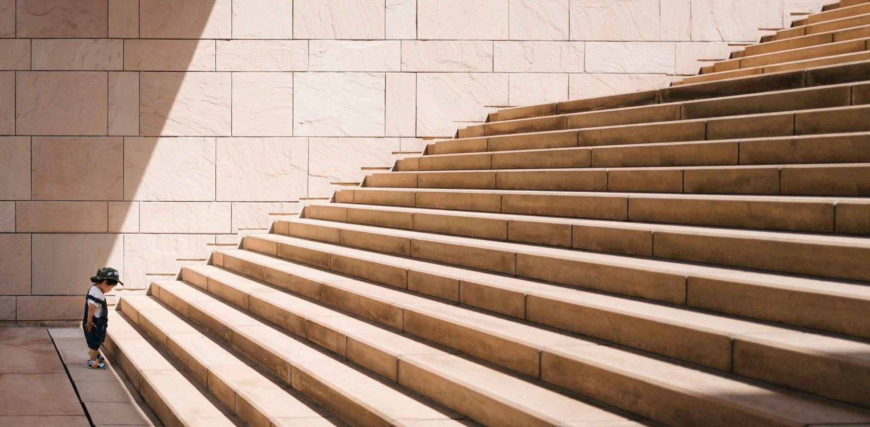 A picture showcasing a child looking at long stone stair case to the goal to start a dental practice