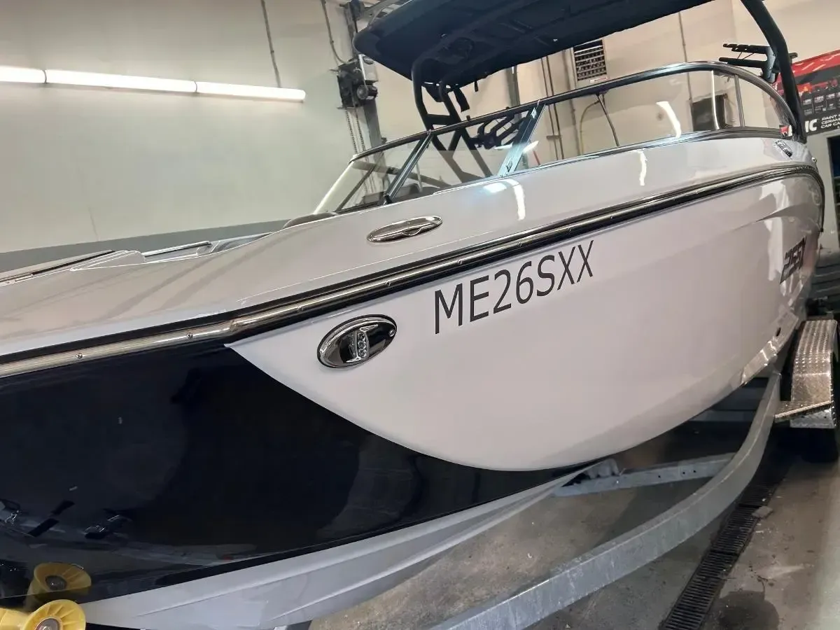 White speedboat on a trailer inside a garage, with registration ME265XX visible.