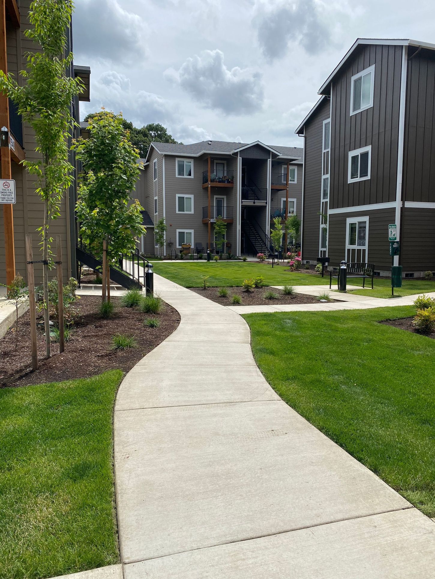 A concrete walkway leading to a row of apartment buildings