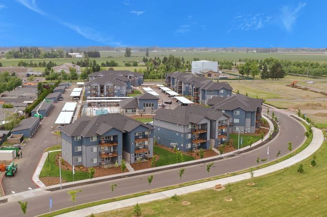 An aerial view of a large apartment complex surrounded by grass and trees.