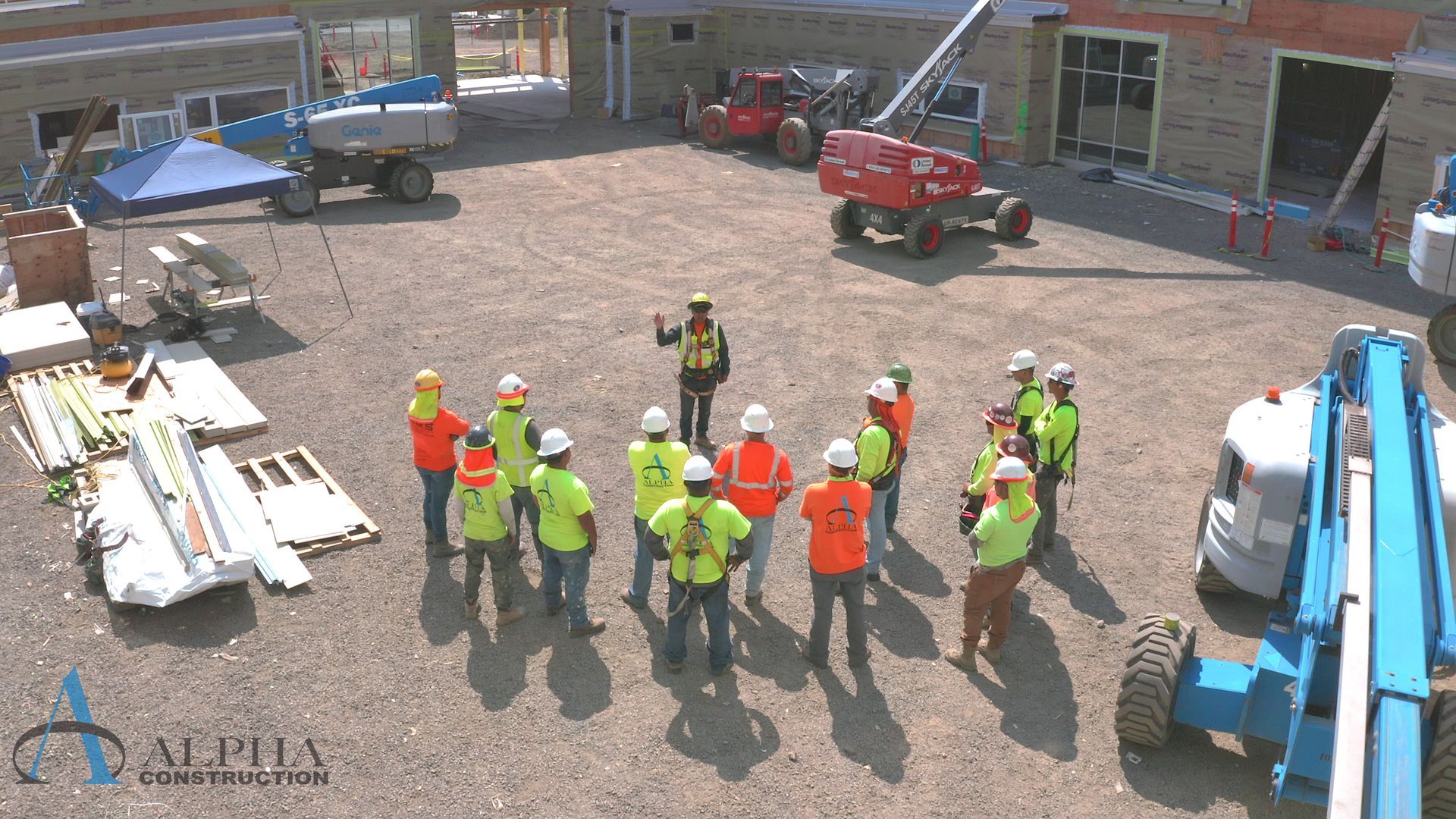 A group of construction workers are standing around talking to each other.