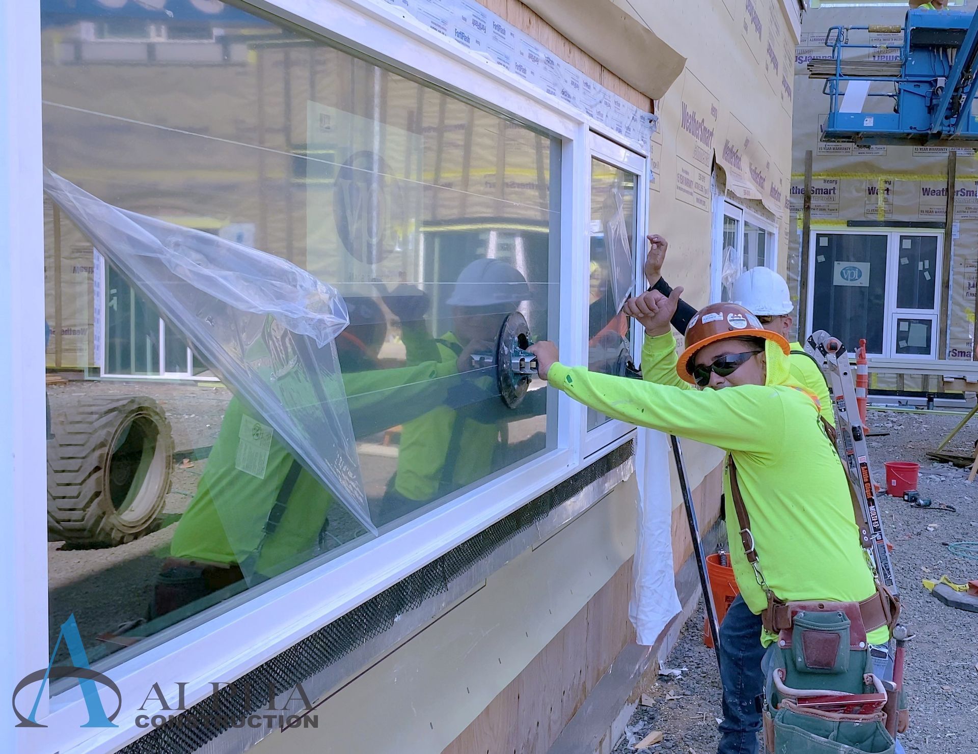 A group of construction workers are installing a window on a building.