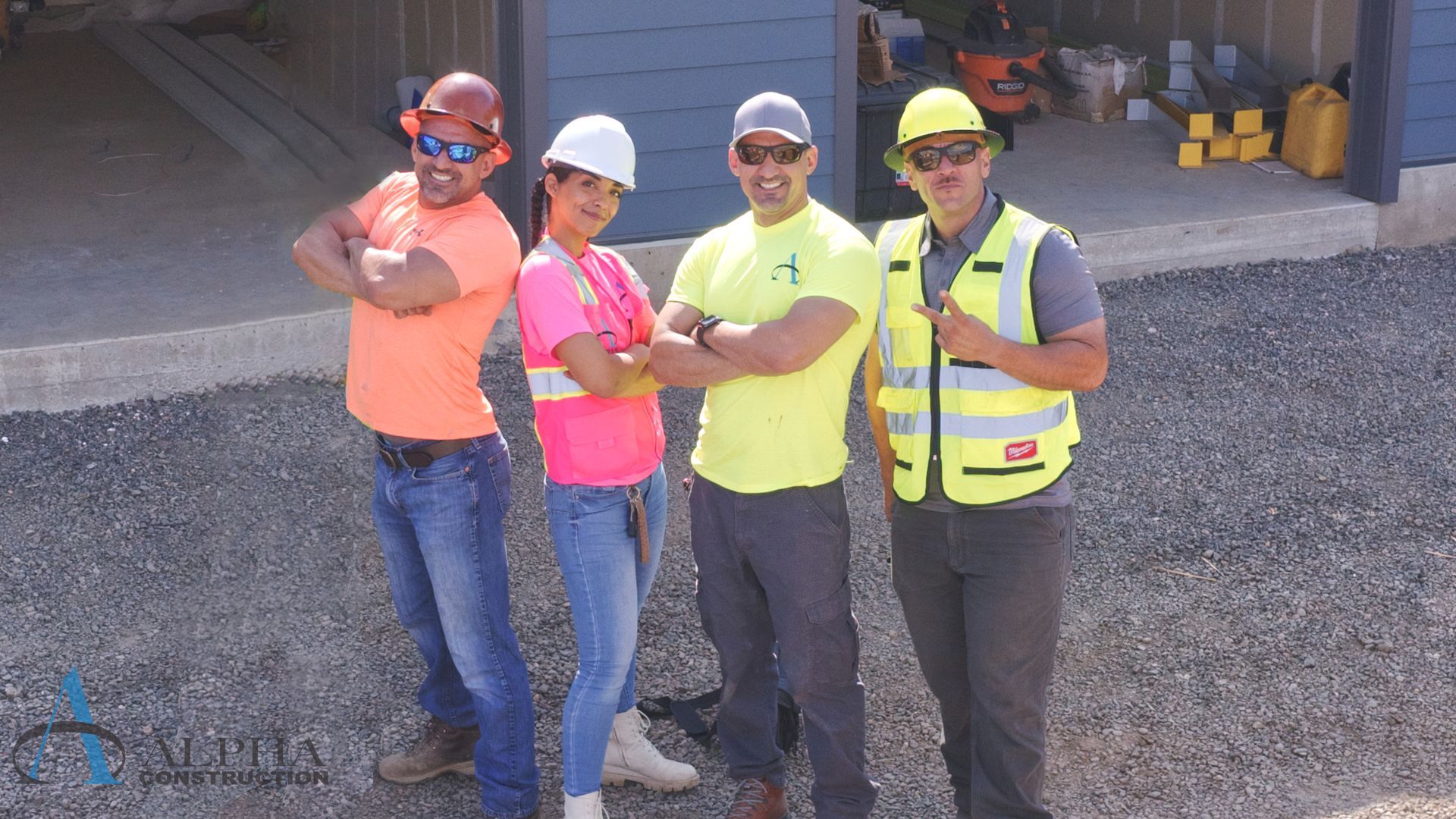 A construction worker is holding a hard hat and a tool belt.