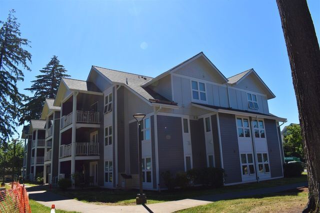 A large apartment building with a tree in front of it
