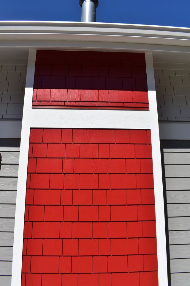 A red and white chimney on the side of a house.