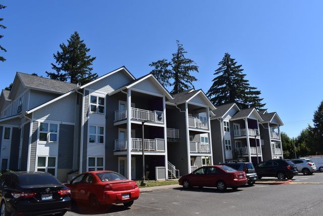 A large apartment building with cars parked in front of it