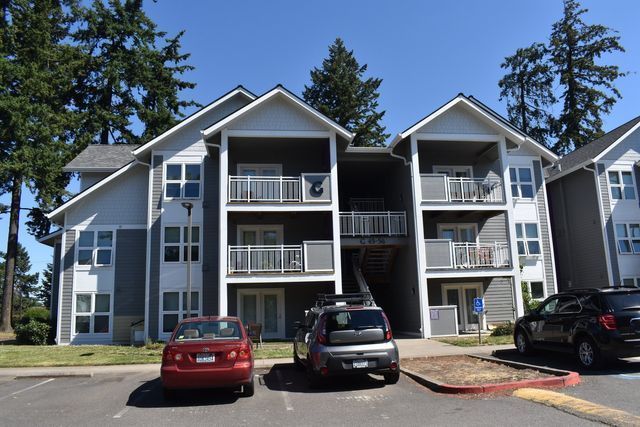A large apartment building with cars parked in front of it