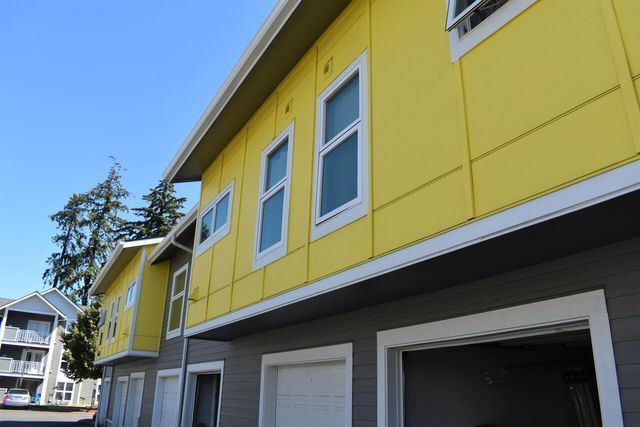 A yellow building with a garage and a blue sky in the background