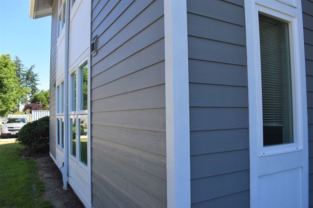 The side of a house with gray siding and white trim