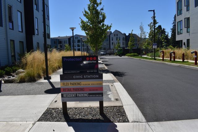 A sign on a sidewalk that says plus parking