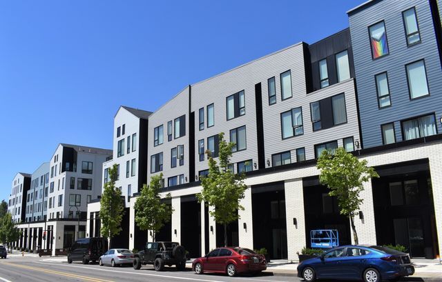 A row of buildings with cars parked in front of them