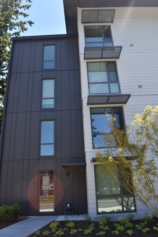 A tall building with a lot of windows and a walkway leading to it.