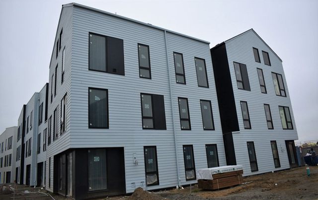 A large white building with a lot of windows is under construction.