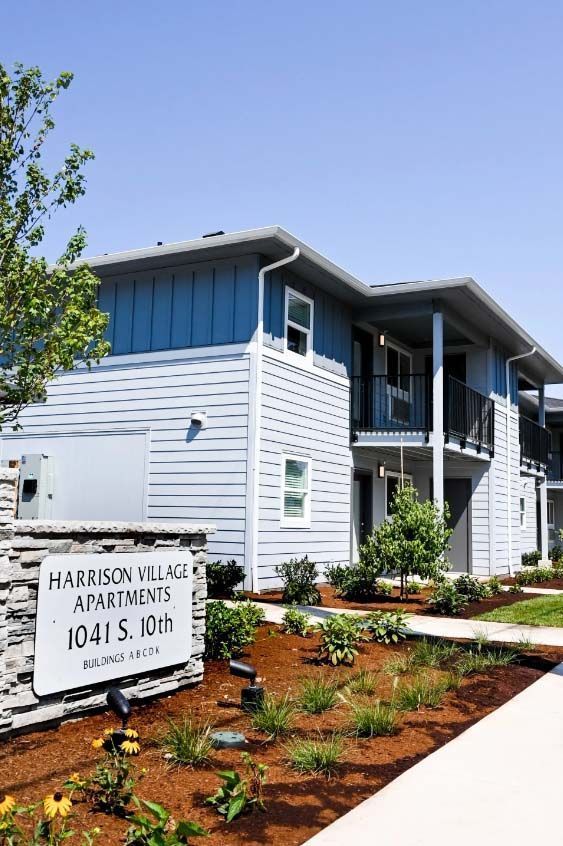 A harrison village apartment building with a sign in front of it