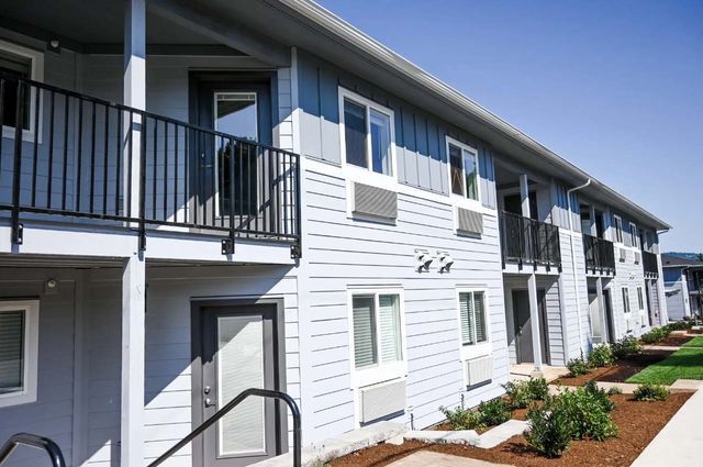 A large apartment building with a balcony and stairs leading to it.