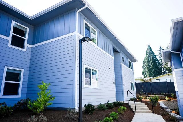 A blue apartment building with stairs leading up to it