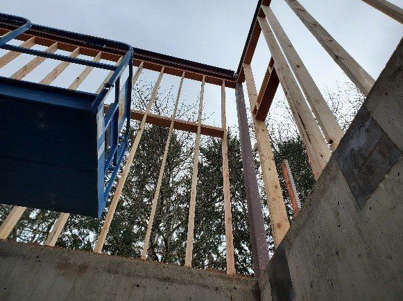 Looking up at a building under construction with trees in the background