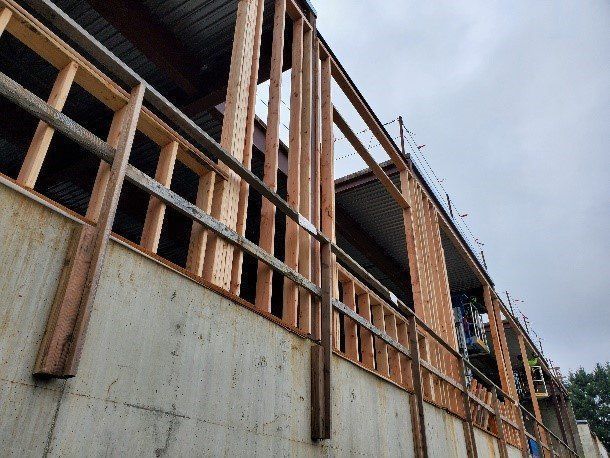 A building is being built with wooden beams and a concrete wall.